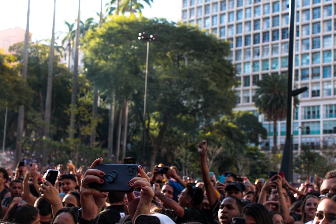 Videographer filming an outdoor public event with a professional camera