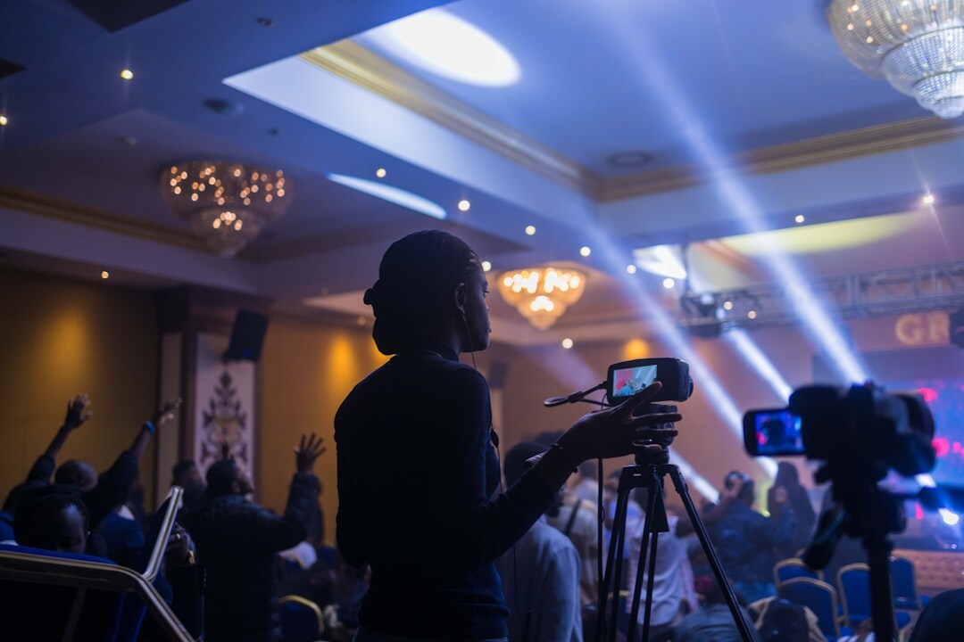 Camera operator filming a conference from the audience