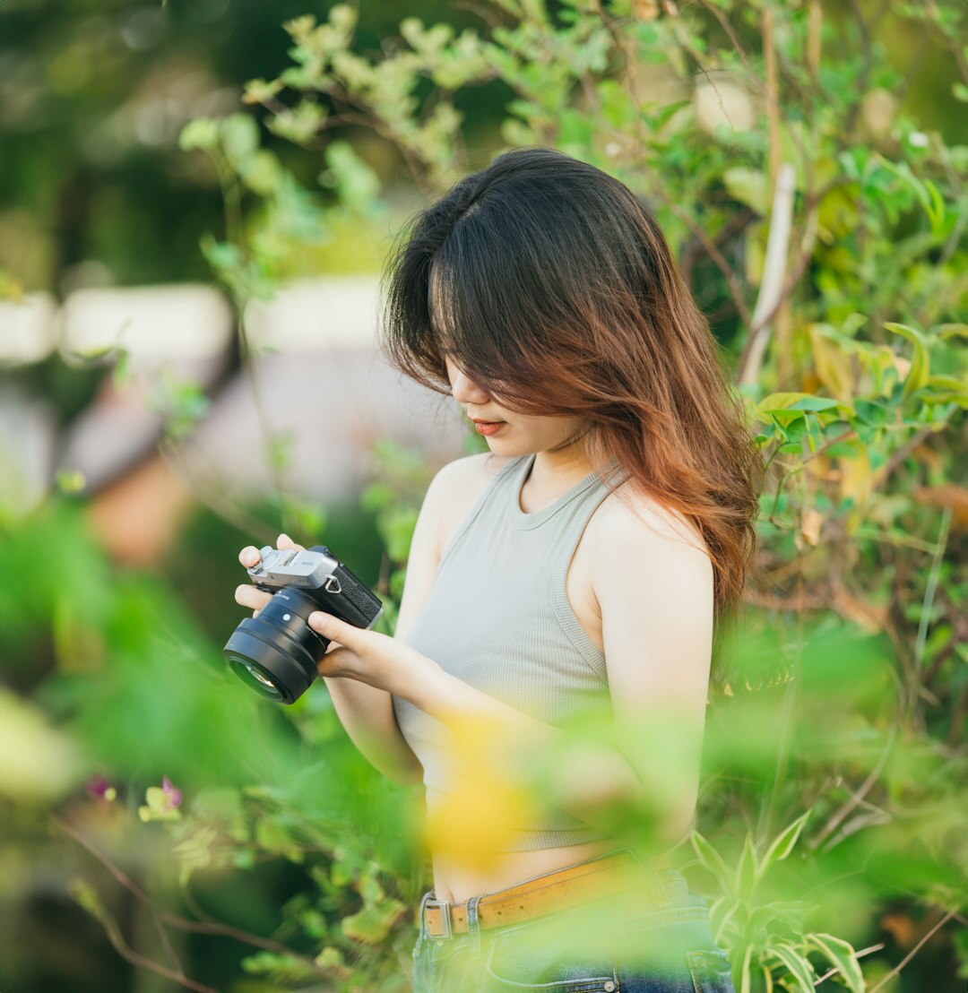 Woman smiling while holding professional camera equipment